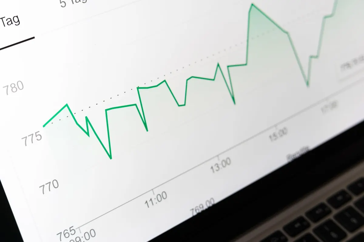 A close-up of a laptop screen showing a green line chart plotted against times of day.